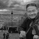 Alain Mather plays for a few Euros a day on the steps of the bascillica Sacre Coeur overlooking the city of Paris, France.